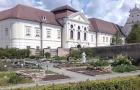 Blick auf den Kräutergarten von Stift Geras mit Stift im HIntergrund.